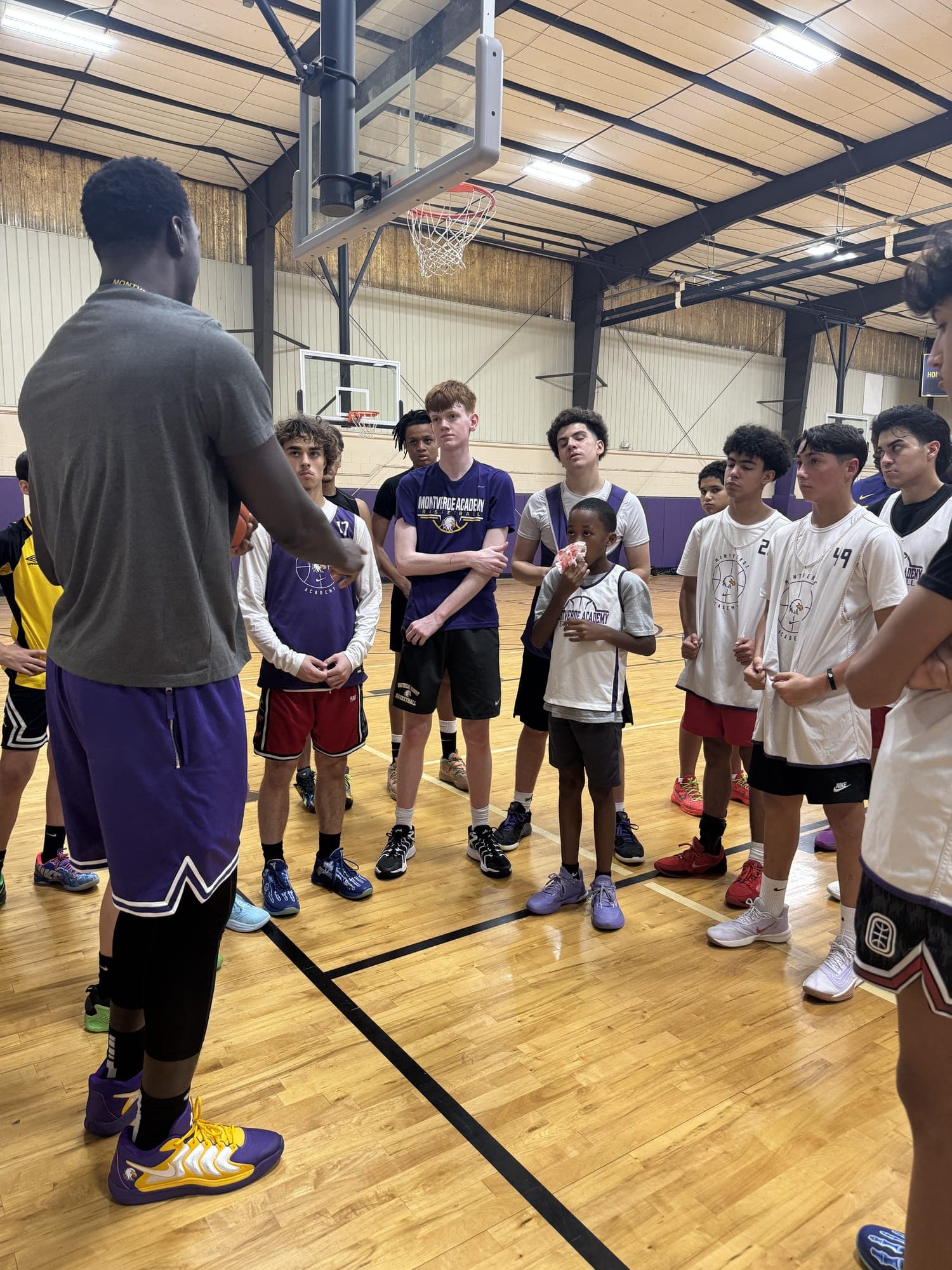 Jogador de basquete ensinando crianças na quadra da Montverde Academy.